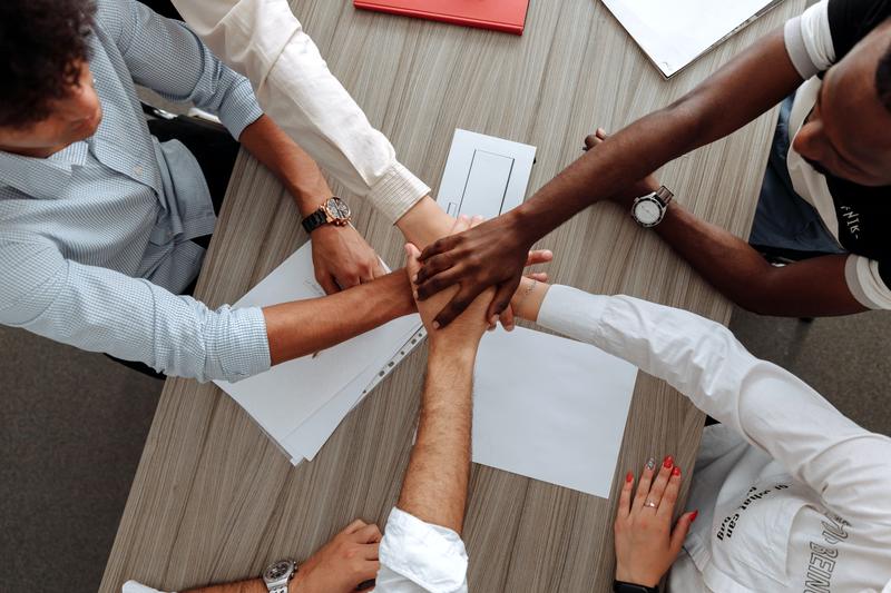 Partners joining hands across a meeting table